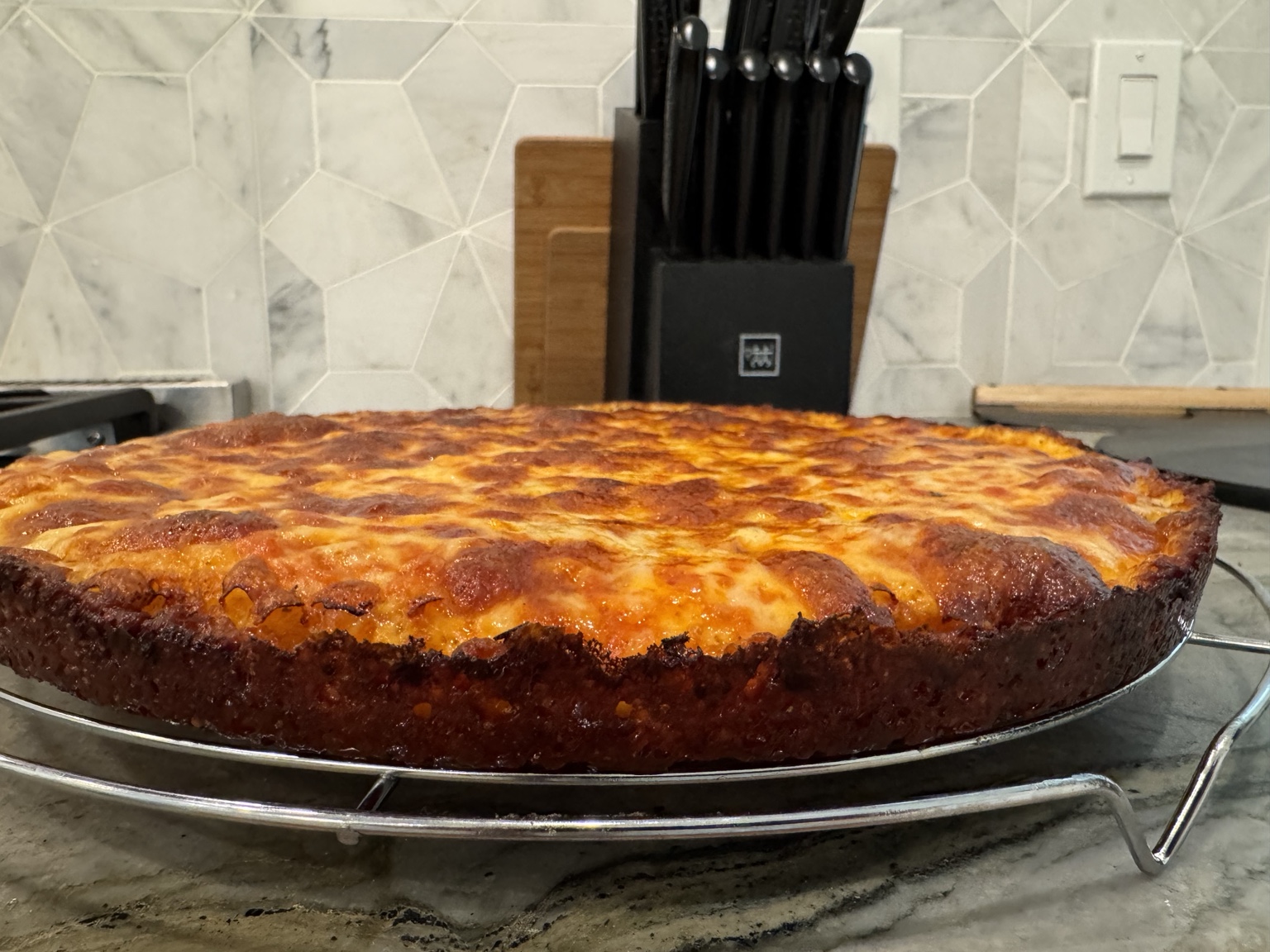 Greg’s golden cheese pan pizza cooling on a rack